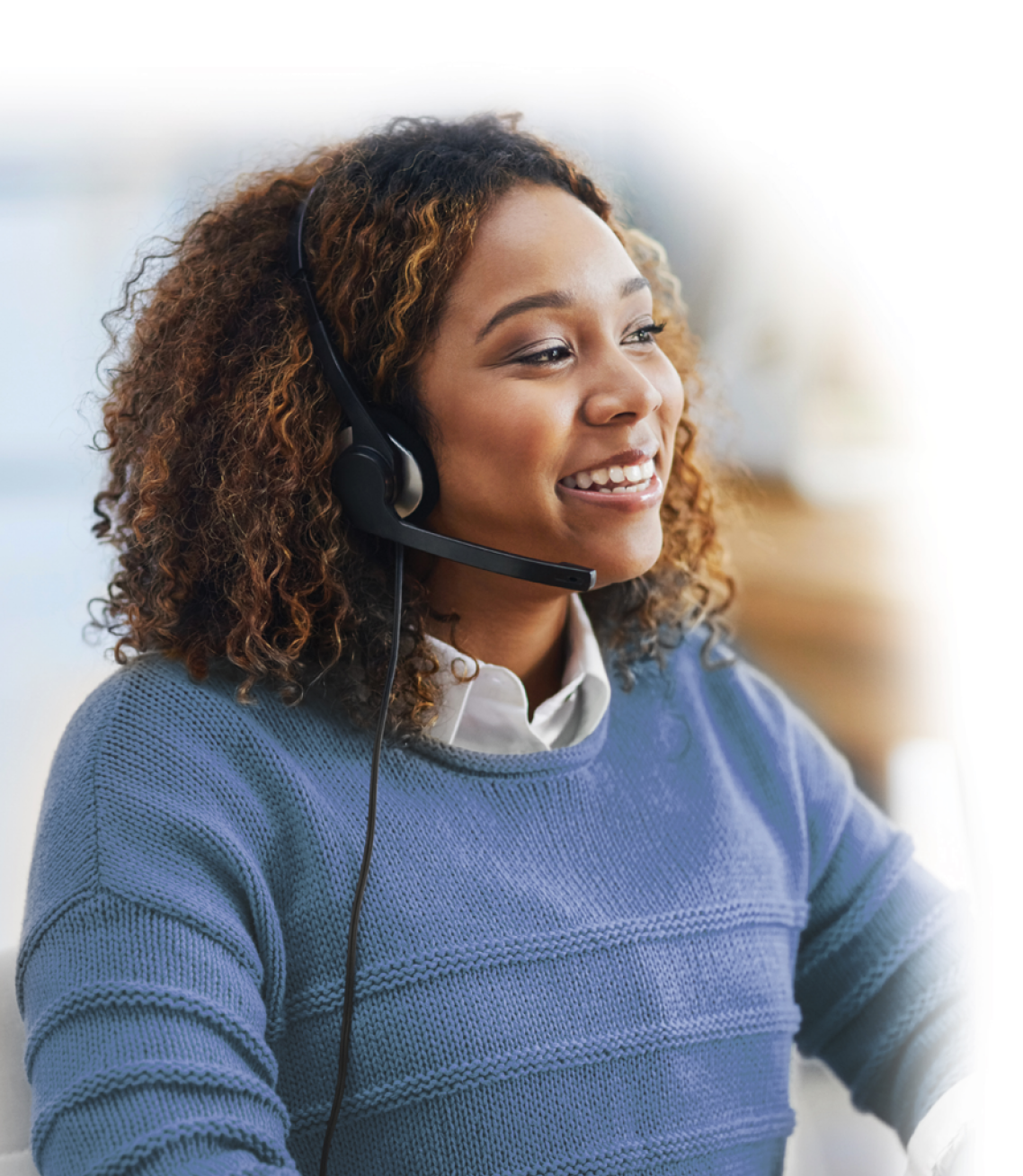 A smiling AB customer service representative taking a call on a headset