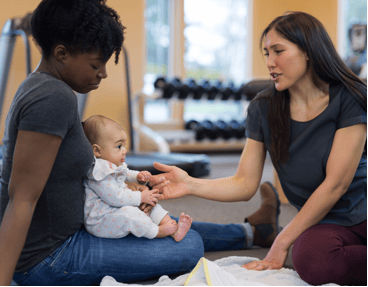 Two women take care of a child