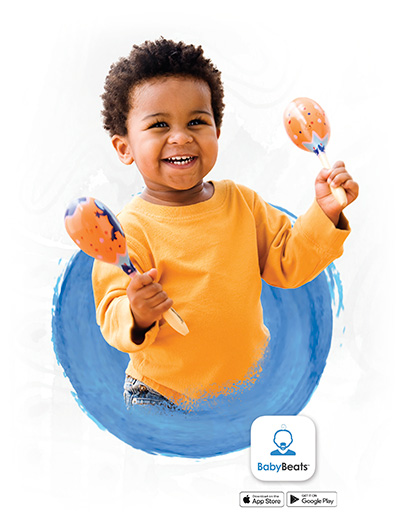 a smiling child holding two maraca instruments